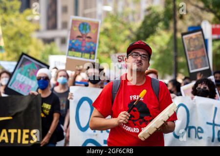 Washington, DC, USA, 23 Agosto, 2021. Nella foto: Joey Peltier della Turtle Mountain Band degli indiani Chippewa, suona un tamburo come marcia di manifestanti contro la linea 3 Enbridge oleodotto durante una dimostrazione sponsorizzata da Shut Down DC e Extinction Rebellion. Il gasdotto passa attraverso le terre del trattato e le sorgenti del fiume Mississippi per trasportare l'olio di sabbie bituminose dal Canada. I suoi impatti ecologici e climatici nei prossimi 50 anni saranno paragonabili alla costruzione e al funzionamento di 50 centrali elettriche a carbone. Credit: Allison Bailey / Alamy Live News Foto Stock