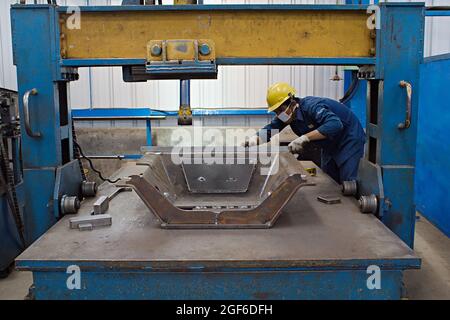 Un tecnico sta misurando un prototipo in un'officina di fabbricazione. Foto Stock
