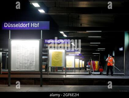 Duesseldorf, Germania. 24 agosto 2021. Un dipendente della Deutsche Bahn pulisce le piattaforme deserte della stazione principale. Il sindacato dei macchinisti GDL ha invitato i suoi membri a sciopero presso la Deutsche Bahn da sabato a mercoledì. Credit: Roland Weihrauch/dpa/Alamy Live News Foto Stock