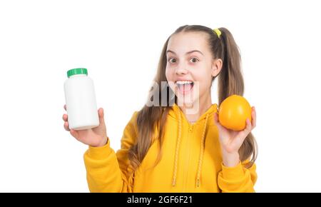 ragazza felice teen scegliere tra frutta d'arancia e pillola di vitamina isolato su bianco, supplemento minerale. Foto Stock