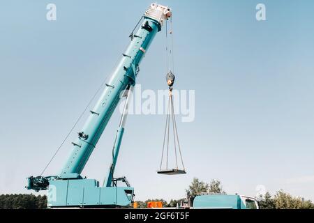 la stufa viene caricata su una grande gru blu per auto e preparata per il funzionamento . La gru per camion più grande per la risoluzione di attività complesse Foto Stock