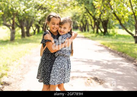 Fortunati a conoscersi. Ragazze intelligenti allegre. Buone studentesse all'aperto. Le piccole scolaresche indossano l'uniforme scolastica. Carino studentesse cercando Foto Stock