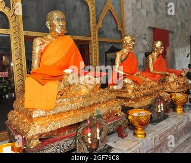Statue di monaci ricoperte di foglie d'oro nel tempio buddista, il monastero buddista di Wat Chalong, l'isola di Phuket, la Thailandia Foto Stock