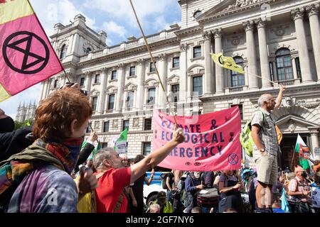 Londra, Inghilterra, Regno Unito 24 agosto 2021 giorno due della ribellione impossibile e gli attivisti del clima gallesi dicono di non nel nostro nome mentre occupano Parliament Street per chiedere all'HMRC di abbandonare il loro rapporto tossico con Barclays. I manifestanti si bloccano sui barili e bloccano la strada Credit: Denise Laura Baker/Alamy Live News Foto Stock