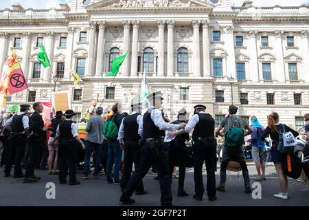 Londra, Inghilterra, Regno Unito 24 agosto 2021 giorno due della ribellione impossibile e gli attivisti del clima gallesi dicono di non nel nostro nome mentre occupano Parliament Street per chiedere all'HMRC di abbandonare il loro rapporto tossico con Barclays. I manifestanti si bloccano sui barili e bloccano la strada Credit: Denise Laura Baker/Alamy Live News Foto Stock