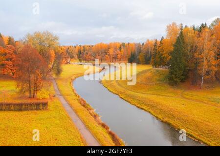 Fiume in autunno parco tra le colline e sentiero per passeggiate, vista aerea Foto Stock