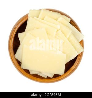 Sottili fette di formaggio Grana Padano, in una ciotola di legno. Formaggi stagionati italiani, simili al parmigiano, di consistenza friabile, dal sapore salato. Foto Stock