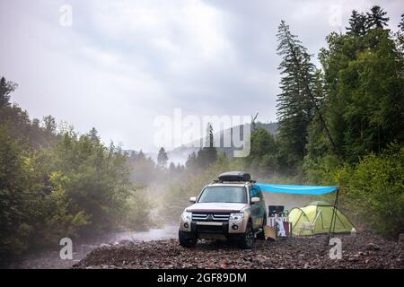 Campeggio auto sul fiume di montagna Foto Stock