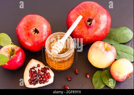 Miele, melograno e mele su tavola nera. Vacanza ebraica Rosh Hashanah sfondo. Foto Stock