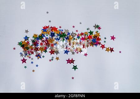 sfondo blu con confetti di stelle multicolore, fuoco selettivo Foto Stock