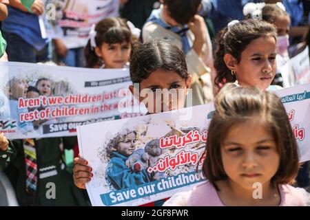 Gaza, Palestina. 24 agosto 2021. I bambini palestinesi tengono striscioni durante un evento per inviare messaggi umanitari al mondo per porre fine all'assedio di Gaza da parte di Israele. Credit: SOPA Images Limited/Alamy Live News Foto Stock