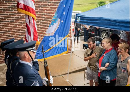 Familiari di Fallen Airman, staff Sgt. Dylan Elchin, stand durante il canto dell'inno nazionale e la presentazione dei colori da parte della 911a Airlift Wing Honor Guard durante una cerimonia di dedizione che rinomina l'ufficio postale a Hookstown, Pennsylvania, 16 agosto 2021. L'ufficio postale è stato rinominato dopo staff Sgt. Dylan Elchin, ucciso da una bomba stradale nella provincia di Ghazni in Afghanistan nel novembre 2018. (STATI UNITI Air Force foto di Joshua J. Seybert) Foto Stock