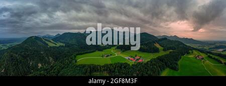 Splendida vista aerea su un terreno agricolo idilliaco nella catena montuosa fino alle alpi bavaresi durante le attività ricreative ed escursionistiche di Chiemgau nella germania meridionale. Foto Stock