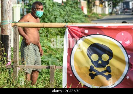 Palu, Indonesia. 24 agosto 2021. La squadra centrale di polizia di Sulawesi (Gegana) ha spruzzato il liquido disinfettante in una zona residenziale a Palu City, Sulawesi centrale. Questo sforzo è stato fatto per rompere la catena della diffusione di Covid-19 che è sempre più prevalente nella zona locale. (Foto di Adi Pranata/Pacific Press/Sipa USA) Credit: Sipa USA/Alamy Live News Foto Stock