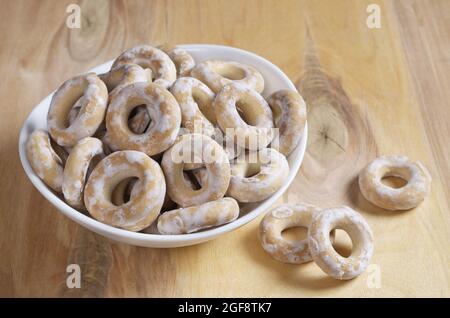 Piccoli bagel smaltati in ciotola su sfondo di legno Foto Stock