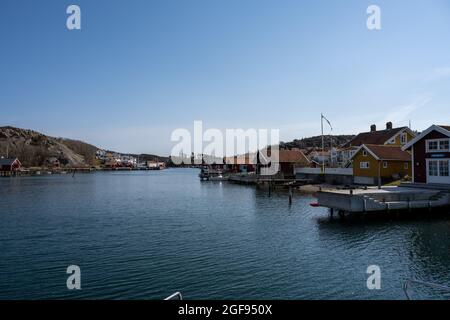 17 aprile 2021 - Hamburgsund, Svezia: Un pittoresco villaggio di pescatori sulla costa occidentale svedese. Tradizionali capanne di mare rosso e un cielo blu sullo sfondo Foto Stock