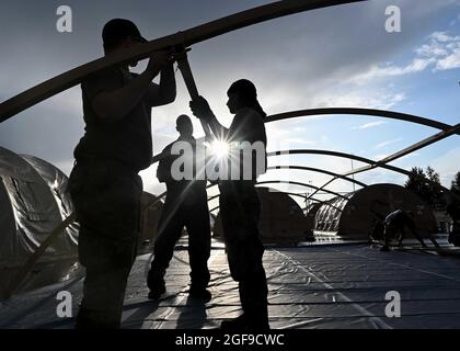 Gli aerei dell'aeronautica degli Stati Uniti, che si sono arenati dal sole che tramonta, assemblano cialde di tenda per i rifugiati afghani evacuati da Kabul alla base aerea di Ramstein il 22 agosto 2021 a Ramstein-Miesenbach, Germania. La base aerea di Ramstein fornisce alloggio temporaneo per gli sfollati dall'Afghanistan come parte del Refuge Operation Allees. Foto Stock