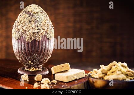 Uovo di pasqua al cioccolato ripieno di paoca e dessert pasquale brasiliano. Foto Stock