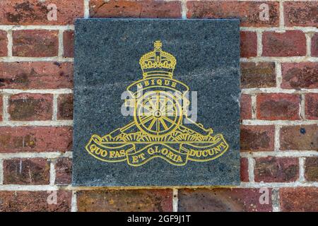 08-24-2021 Portsmouth, Hampshire, Regno Unito, l'emblema o cresta dell'artiglieria reale su una placca su un muro di mattoni Foto Stock