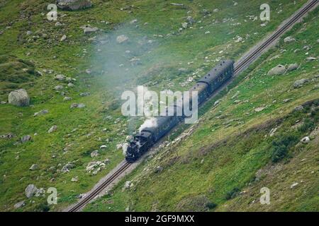 Treno a vapore Furka attraverso i paesaggi montani delle Alpi centrali sulla storica Glacier Express. Furkapass, Svizzera - Agosto 2021 Foto Stock