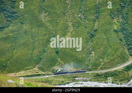 Treno a vapore Furka attraverso i paesaggi montani delle Alpi centrali sulla storica Glacier Express. Furkapass, Svizzera - Agosto 2021 Foto Stock