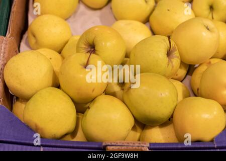 Mele gialle come sfondo, in un mercato. Foto Stock