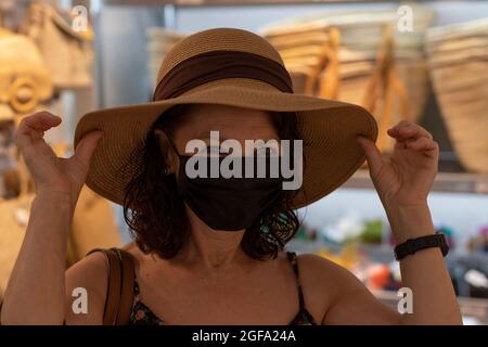 Bella donna in cappello e maschera facciale. Foto Stock