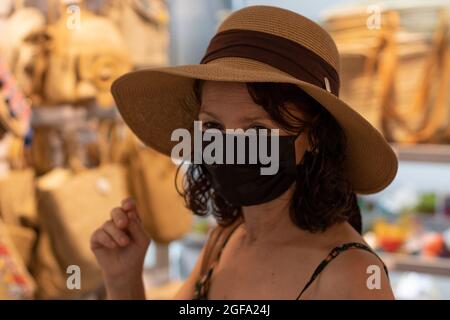 Bella donna in cappello e maschera facciale. Foto Stock