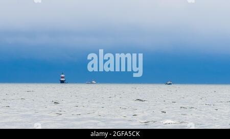 NORWALK, CONNECTICUT - 23 AGOSTO 2021: Due barche di ostriche giorno dopo l'uragano Henri vicino al faro di Peck Ledge visto da Calf Pasture Beach Foto Stock