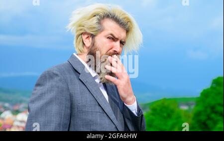Uomo fumante. Uomo elegante con baco di sigaretta. Uomo d'affari in abito fumo sigaretta. Foto Stock