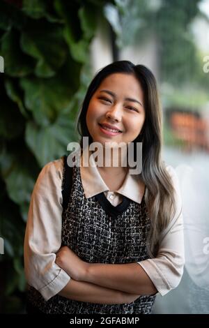 Giovane Asian donna Ufficio lavoratore / Data Scientist guardando fuori finestra Foto Stock