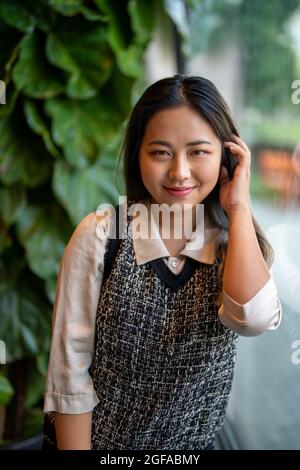 Giovane Asian donna Ufficio lavoratore / Data Scientist guardando fuori finestra Foto Stock