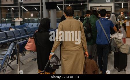 Ramstein Miesenbach, Germania. 23 Agosto 2021. I cittadini degli Stati Uniti evacuati da Kabul si riuniscono presso l'edificio del terminal aeroportuale per la partenza negli Stati Uniti alla base aerea di Ramstein il 23 agosto 2021 a Ramstein-Miesenbach, Germania. Ramstein sta fornendo alloggio temporaneo per gli sfollati dall'Afghanistan come parte dell'operazione Allees Refuge. Credit: Planetpix/Alamy Live News Foto Stock