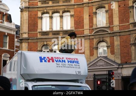 Cambridge Circus, Londra, Regno Unito. 24 agosto 2021. I manifestanti del cambiamento climatico provenienti dalla ribellione di estinzione che protestava a Cambridge Circus , bloccando Charing Cross Road lungo la strada per Trafalgar Square. L'attivista sale in cima a un furgone bianco. Credit: Xiu Bao/Alamy Live News Foto Stock