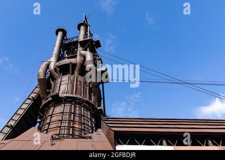 Struttura industriale molto alta contro un cielo blu profondo, patina di superficie in metallo arrugginito, aspetto orizzontale Foto Stock