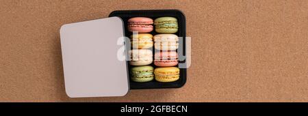 Macaron selezione di sapori in confezione regalo vista dall'alto sfondo marrone Foto Stock