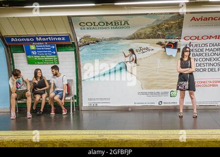 Madrid Spagna,Hispanic Chamberi,piattaforma metropolitana della stazione Alonzo Martinez,affissioni pubblicità uomo donna maschio donna donna in attesa di amici, Foto Stock