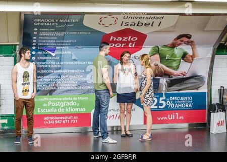 Madrid Spagna,Hispanic Chamberi,piattaforma metropolitana della stazione Alonzo Martinez,affissioni pubblicità uomo donna maschio donna donna in attesa di amici, Foto Stock