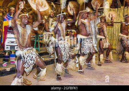 Johannesburg Sud Africa, Lesedi African Lodge & Cultural Village, Zulu Xhosa Pedi Basotho Ndebele tribù Black Africam. Uomini donne madrelingua regalia traina Foto Stock