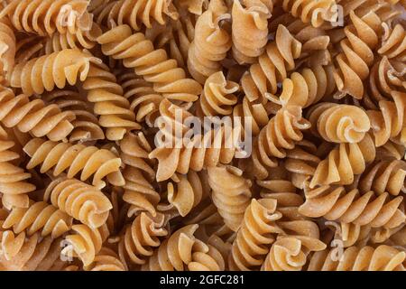 Fondo di pasta di fusilli di grano saraceno crudo senza glutine. Macaroni senza glutine integrali. Sfondo alimentare. Foto Stock