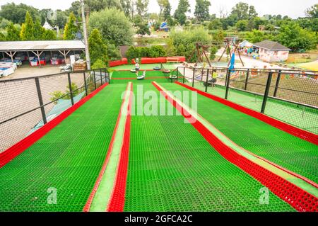 KOSCIAN, POLONIA - 01 ago 2021: Una pista verde e rossa al parco divertimenti Nenufar Club di Kospian, Polonia Foto Stock