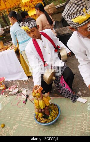 Un musicista che prende sacre offerte di fronte all'altare della dea Saraswati nel Tempio di Ceho, commemorando il giorno di Saraswati - un giorno in cui la conoscenza è entrata nell'umanità. Centro di Java, Indonesia. 6 giugno 2008. Foto Stock