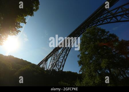 Solingen, Germania. 25 ago 2021. Il ponte ferroviario di Müngsten, un ponte a traliccio in acciaio, conduce su una valle del Wupper. La costruzione fu completata nel 1897 e fu chiamata 'Kaiser-Wilhelm-Brücke' fino al 1918. L'imponente struttura è la proposta della Renania Settentrionale-Vestfalia di un elenco di domande per i futuri siti del Patrimonio Mondiale della Conferenza dei Ministri della Cultura. Credit: David Young/dpa/Alamy Live News Foto Stock