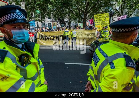 Londra, Regno Unito. 25 ago 2021. I manifestanti al di fuori dell'ambasciata brasiliana chiedono di porre fine agli attacchi contro le popolazioni indigene del Brasile. Tra i sostenitori vi sono Amazon Rebellion, Brazil Matters, CAFOD, Greenpeace, Parents for Future e Survival International. Essi sono solidali con l’APIB contro il “Marco Temporal” (o “Time Limit Trick”)*, progetto di legge 490 noto come “Bill of Death”, dal governo Bolsonaro la ribellione di estinzione si unisce come parte della loro due settimane il nome della ribellione impossibile, a Londra. Credit: Guy Bell/Alamy Live News Foto Stock