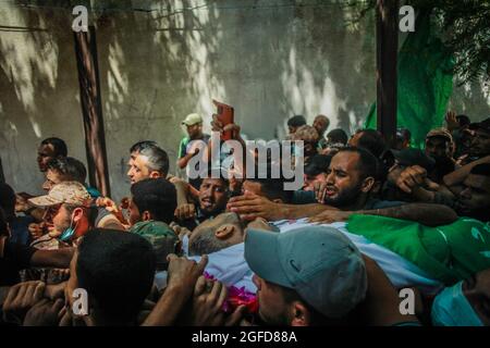 I lutto palestinesi trasportano il corpo di Osama Deeij, morto di una ferita che ha sostenuto durante una protesta anti-Israele contro la recinzione di confine Israele-Gaza la settimana scorsa, durante il suo funerale al campo profughi di Jabalia nella striscia settentrionale di Gaza il 25 agosto 2021. Foto di Ramez Habboub/ABACAPRESS.COM Foto Stock