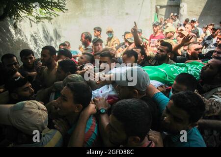 I lutto palestinesi trasportano il corpo di Osama Deeij, morto di una ferita che ha sostenuto durante una protesta anti-Israele contro la recinzione di confine Israele-Gaza la settimana scorsa, durante il suo funerale al campo profughi di Jabalia nella striscia settentrionale di Gaza il 25 agosto 2021. Foto di Ramez Habboub/ABACAPRESS.COM Foto Stock