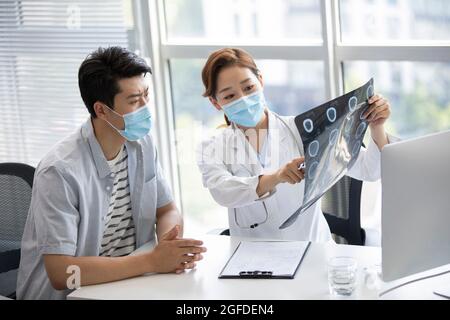 Il medico discute l'immagine radiologica con il paziente Foto Stock