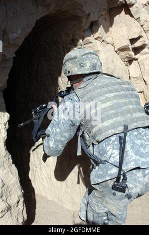 Un soldato della Charlie Company, 2/87 fanteria, entra e libera una grotta situata sulla cima di una montagna nella provincia di Paktika in Afghanistan, marzo 29. Il soldato ha partecipato all'operazione Catamount Fury, una missione di dimensioni battaglione focalizzata sulla limitazione del movimento dei talebani all'interno della provincia. Foto Stock