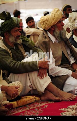 Un anziano di villaggio siede come l'ex comandante talebano parla durante la shura marzo 17, nel villaggio di Sorkh-AB, nel distretto di Muhammed Aga, provincia di Logar, Afghanistan. Foto Stock