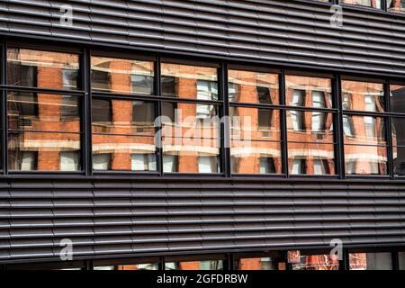 Moderno edificio urbano contemporaneo con metallo, finestre e riflessi. Foto Stock